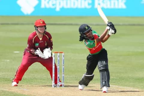 A Guyana Amazon Warriors batter plays a shot square of the wicket as the keeper crouches behind the stumps